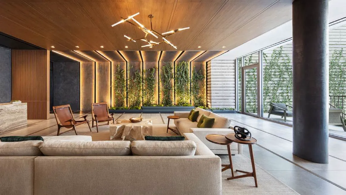 2200 Brickell — lounge de residentes con techo de madera, muro vegetal iluminado y ventanales corredizos hacia la terraza