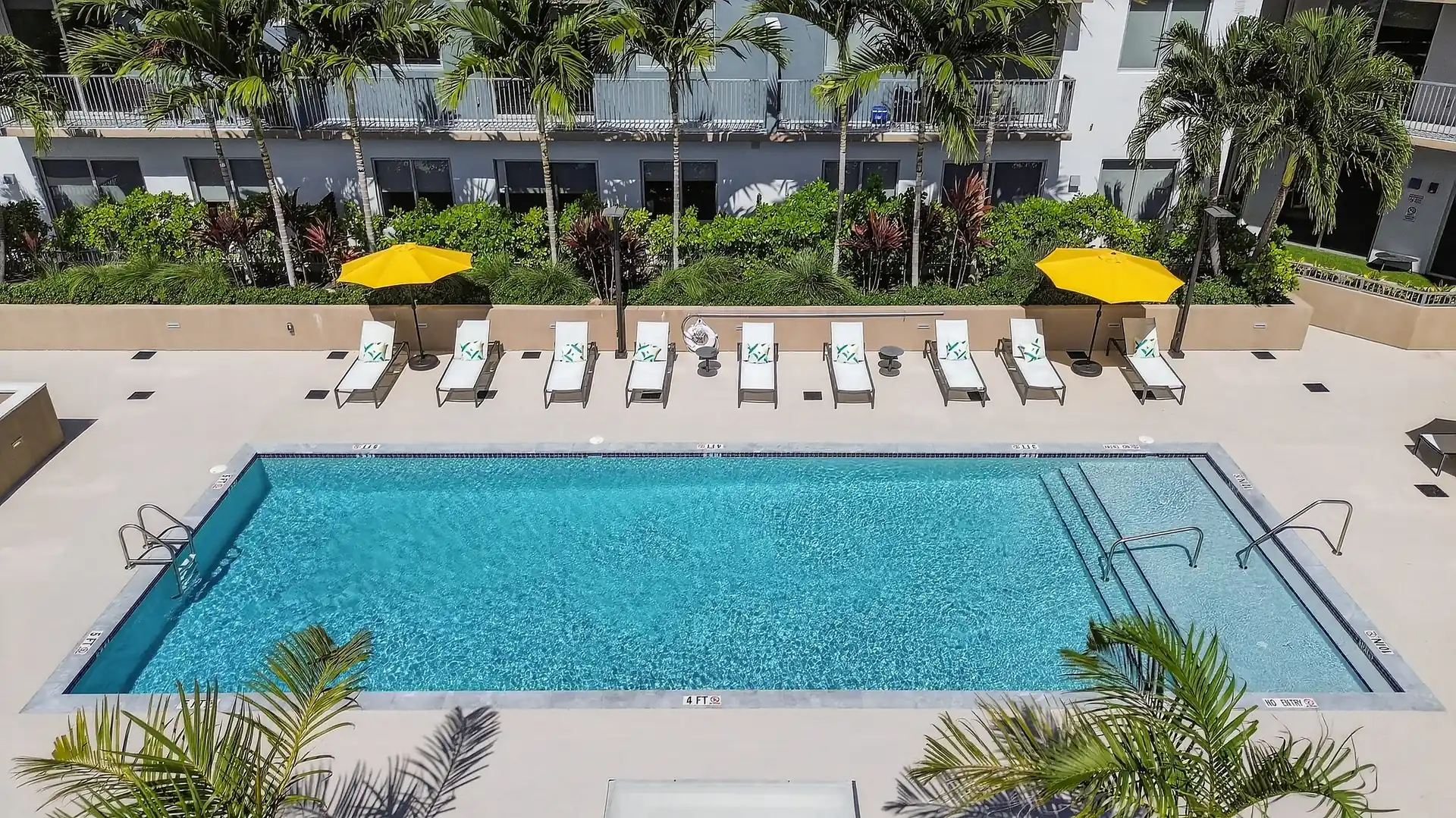 Centralis Residences — vista aérea de la terraza de piscina con camastros, sombrillas y palmeras