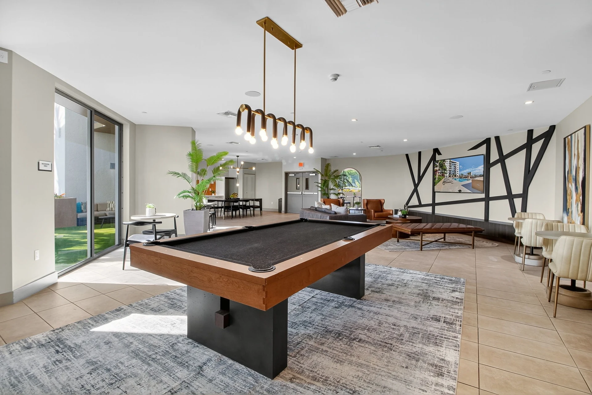 Centralis Residences — salón para residentes con mesa de billar, zona de sillones y salida a la terraza