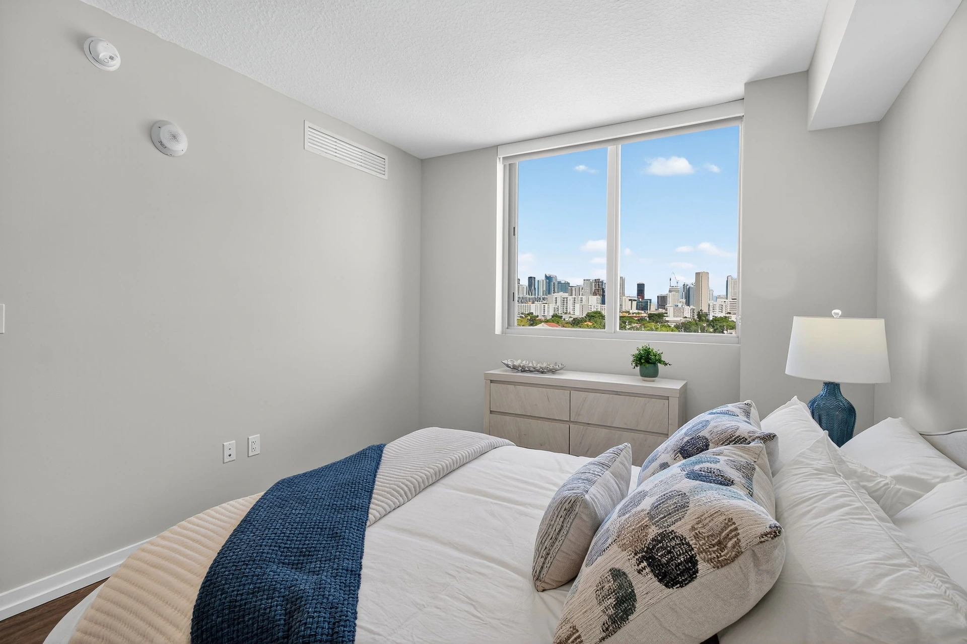Centralis Residences — dormitorio con ventana panorámica y vista al skyline de Miami