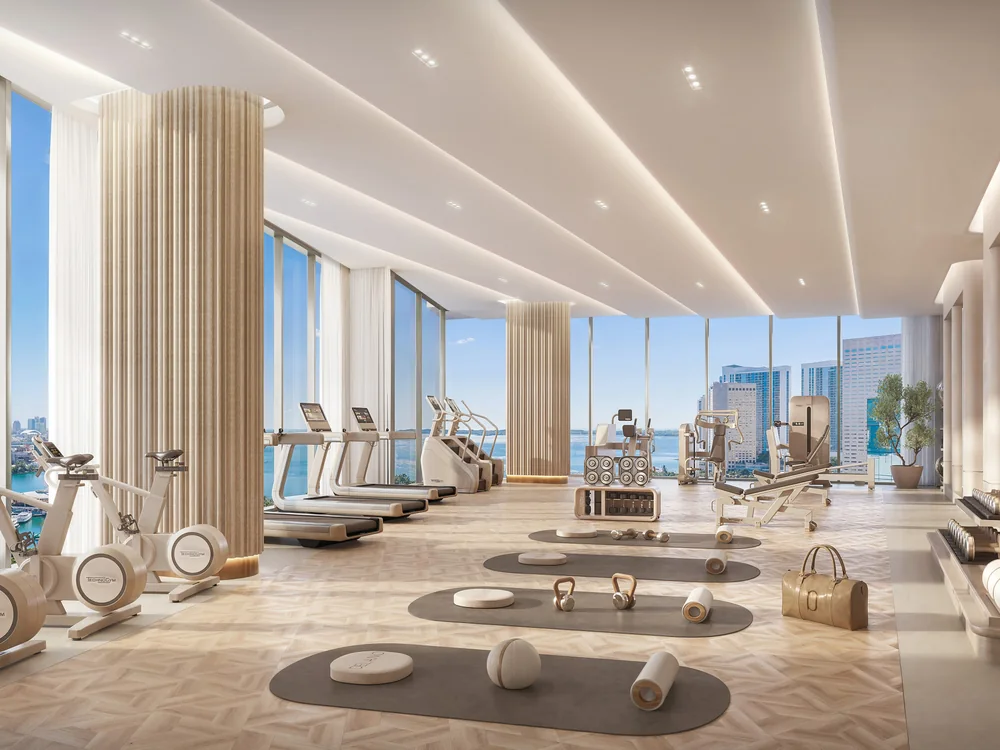 Delano Residences — gimnasio de planta completa con equipos, zona de esterillas y ventanales a la ciudad