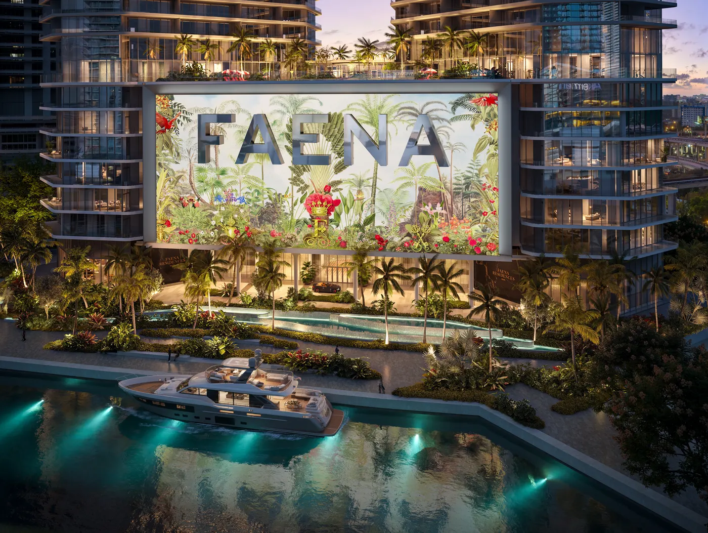 Fachada de Faena Residences Miami al anochecer con el mural artístico "FAENA" de gran formato entre las dos torres y un yate amarrado en el canal frente al edificio