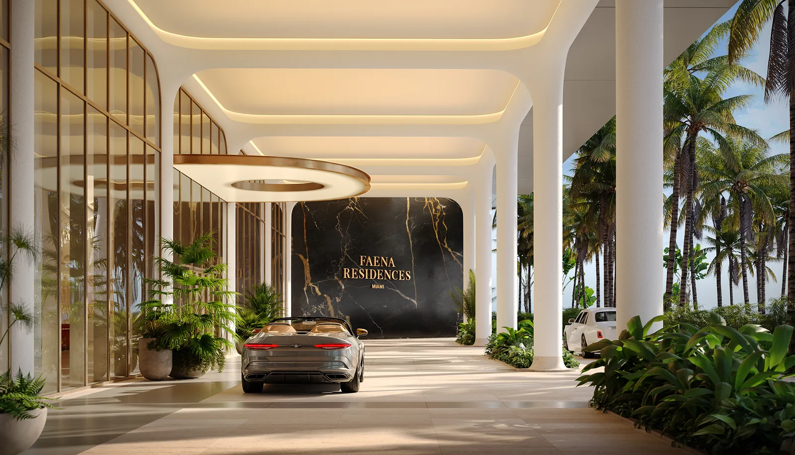 Porte cochère de Faena Residences Miami de día, con la señalética en mármol negro del proyecto, un auto descapotable y palmeras a los costados