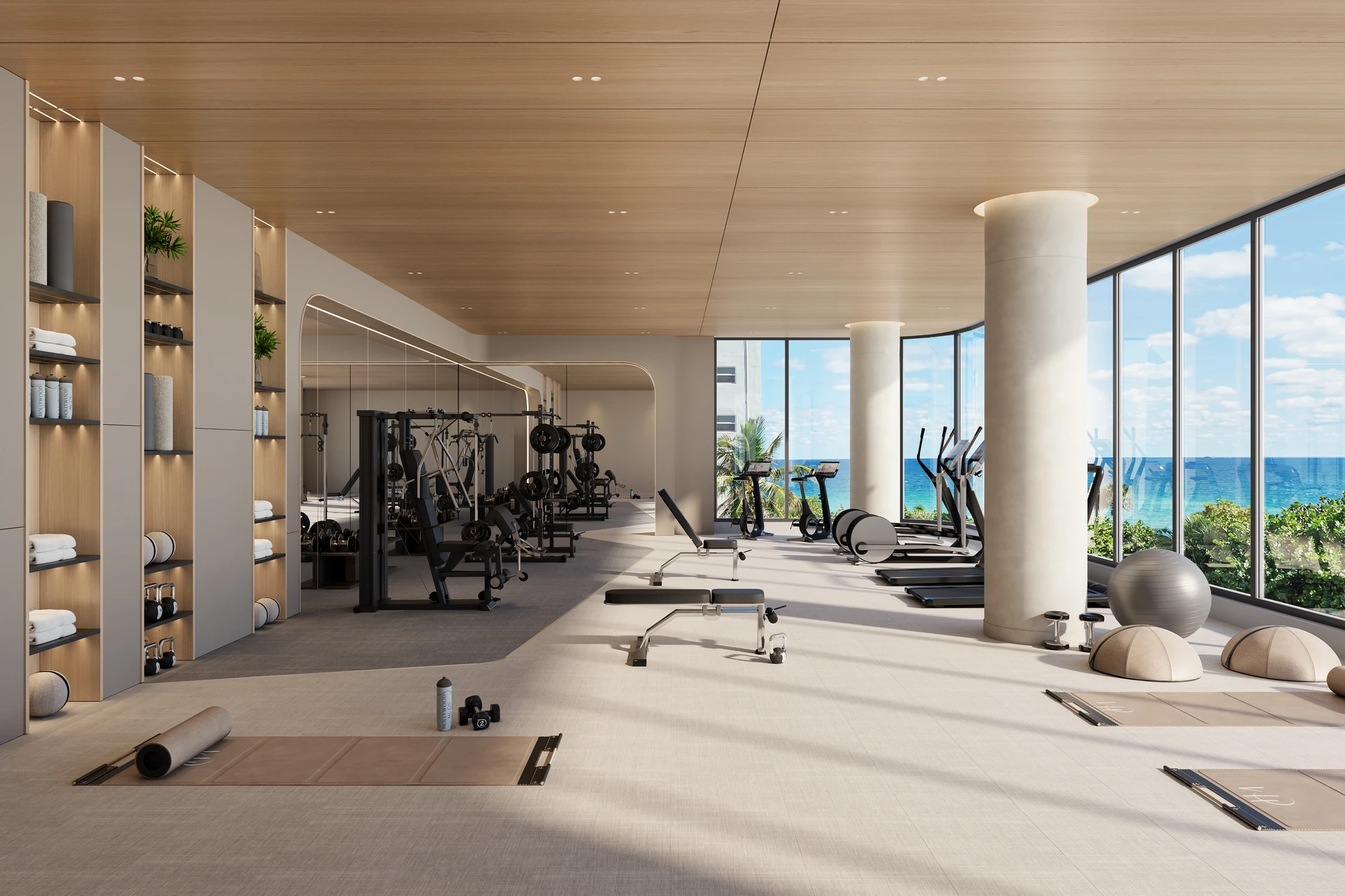 Hollywood Moon — gimnasio Vitality con máquinas de fuerza y cardio, cielorraso de madera y ventanales de piso a techo hacia el agua