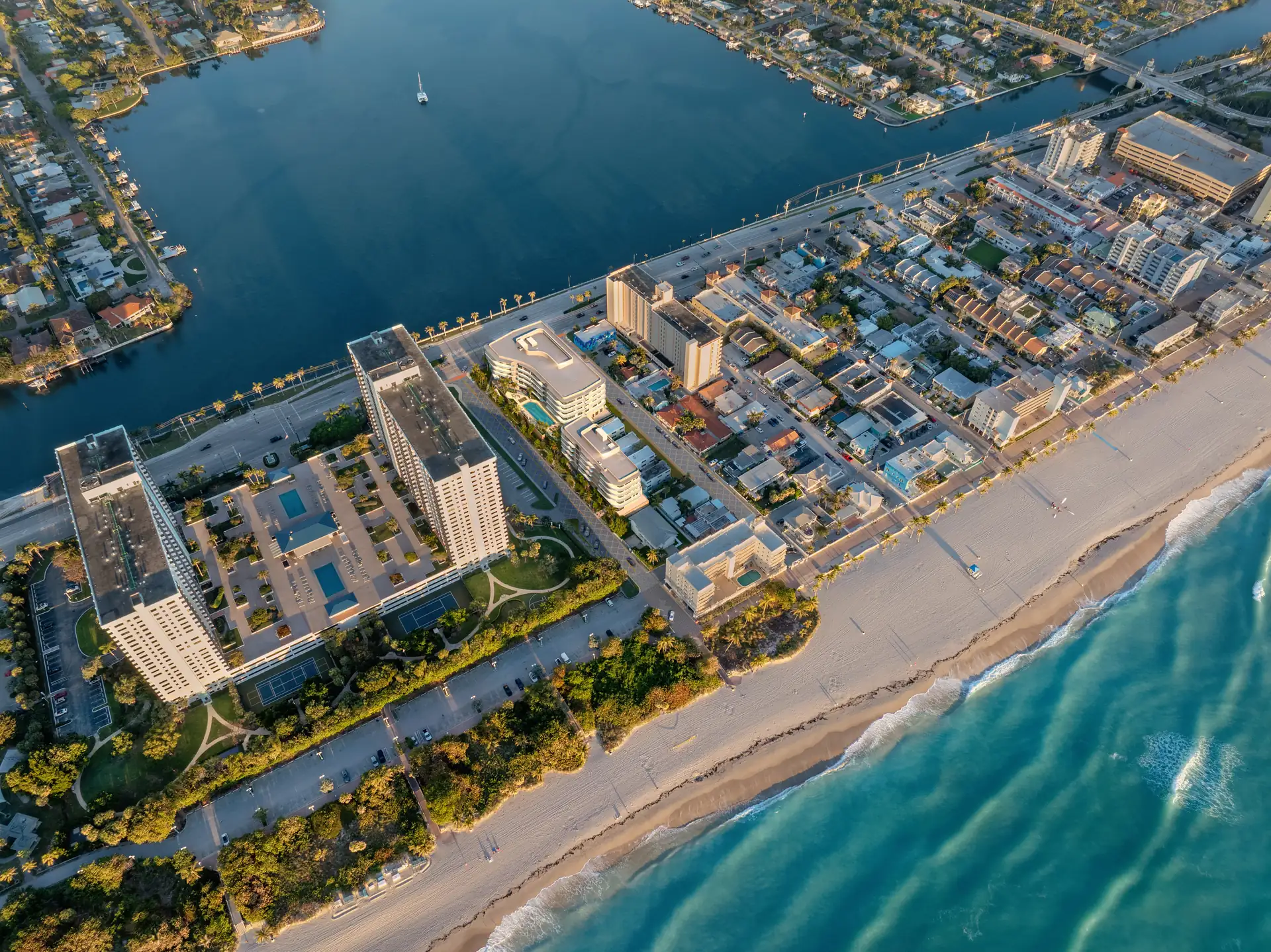 Hollywood Moon — vista aérea de la isla barrera de Hollywood Beach: el océano Atlántico y la playa a un lado, el canal Intracoastal y las marinas al otro