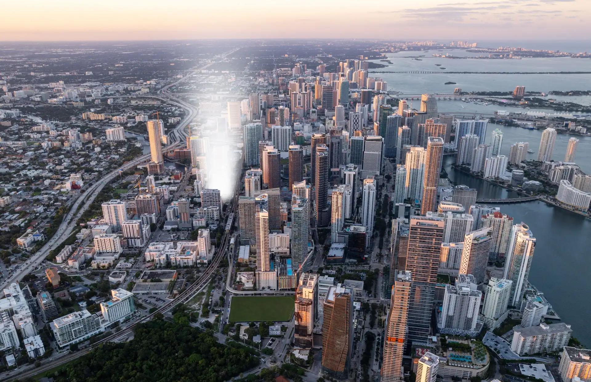 Vista aérea de Brickell al atardecer: la densidad de torres del distrito financiero entre el río Miami y la bahía de Biscayne