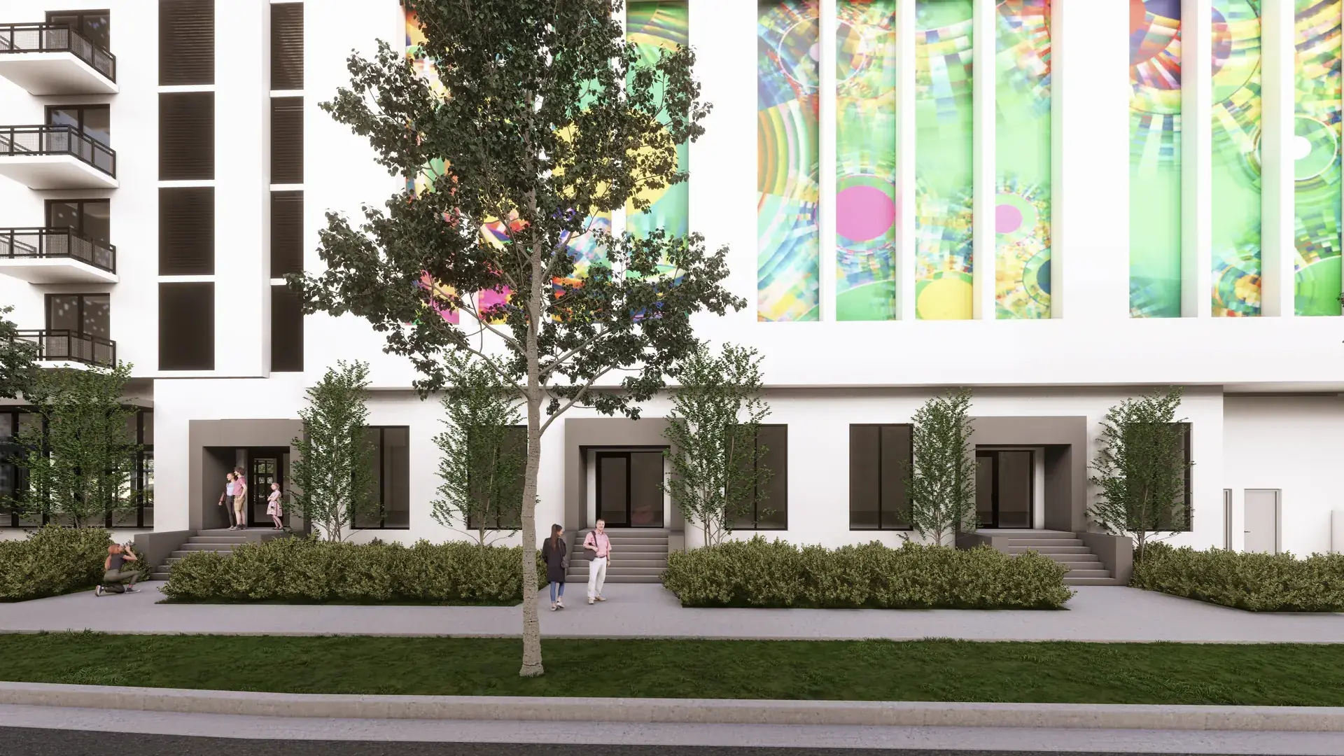 River District 14 — las residencias de entrada privada a nivel de calle, con sus escalinatas propias, el seto recortado y el mural de color de la fachada al fondo