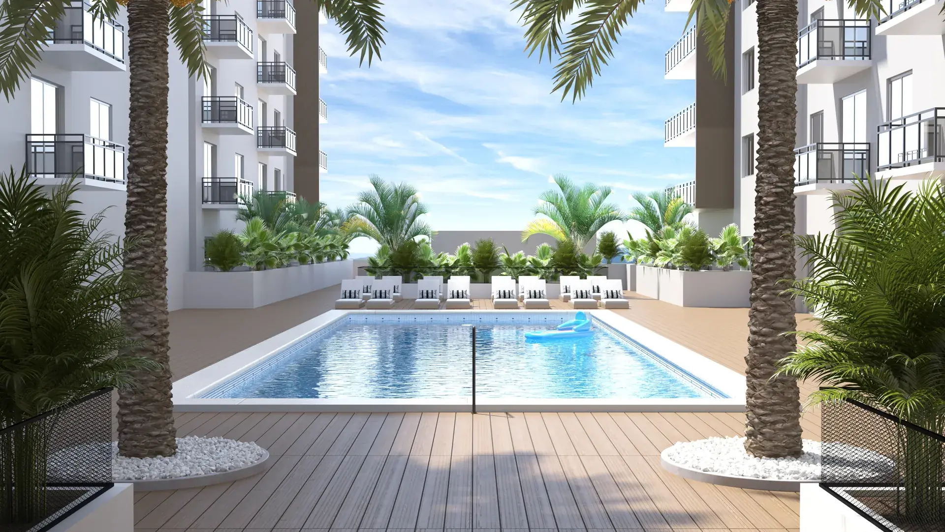 River District 14 — piscina estilo resort en el patio interior del edificio, con deck de madera, camastros, palmeras y las fachadas de las dos alas a los lados