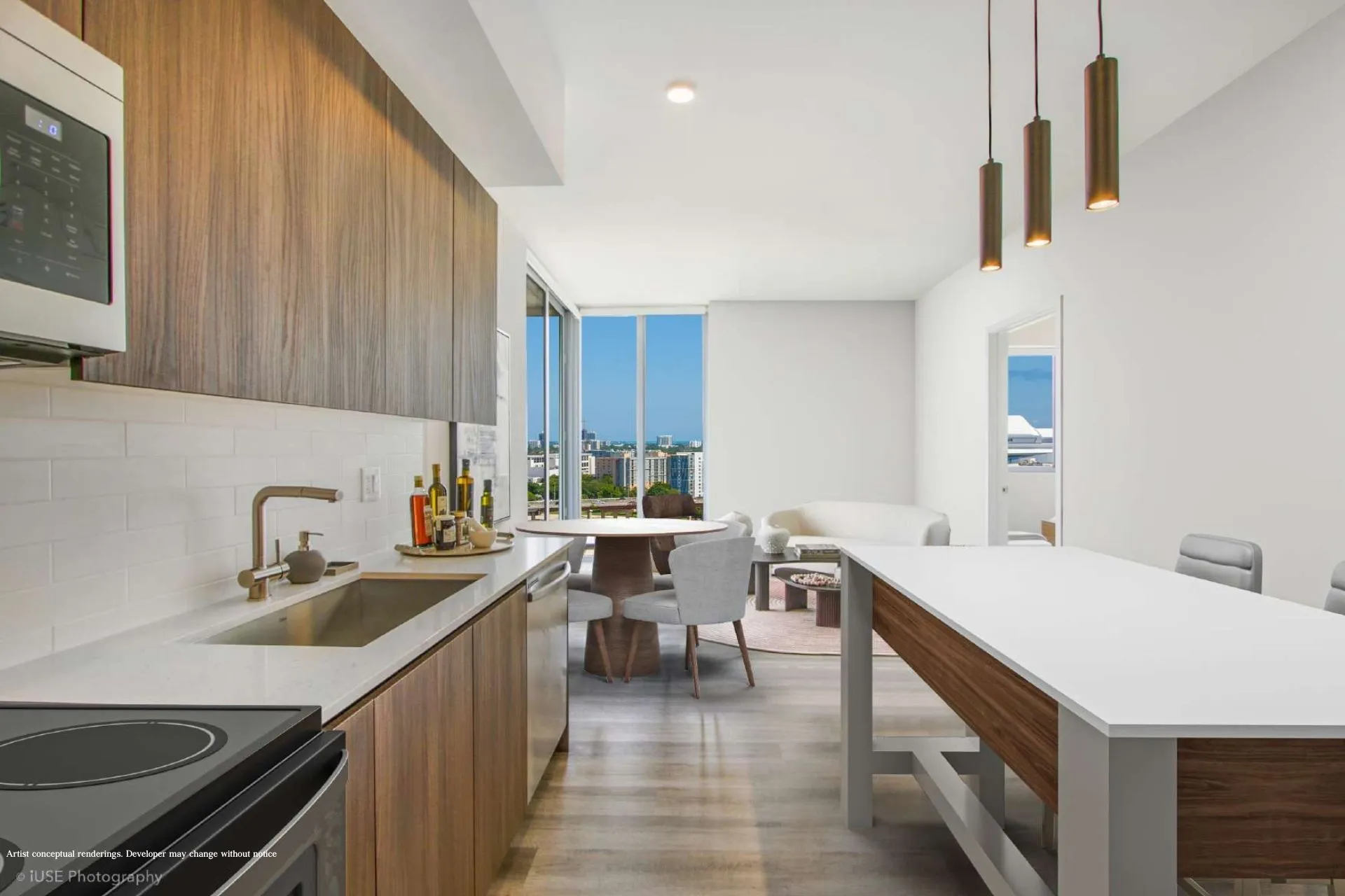 River District 14 — cocina de una residencia con gabinetes de madera, electrodomésticos de acero inoxidable, isla con barra blanca y el comedor junto al ventanal