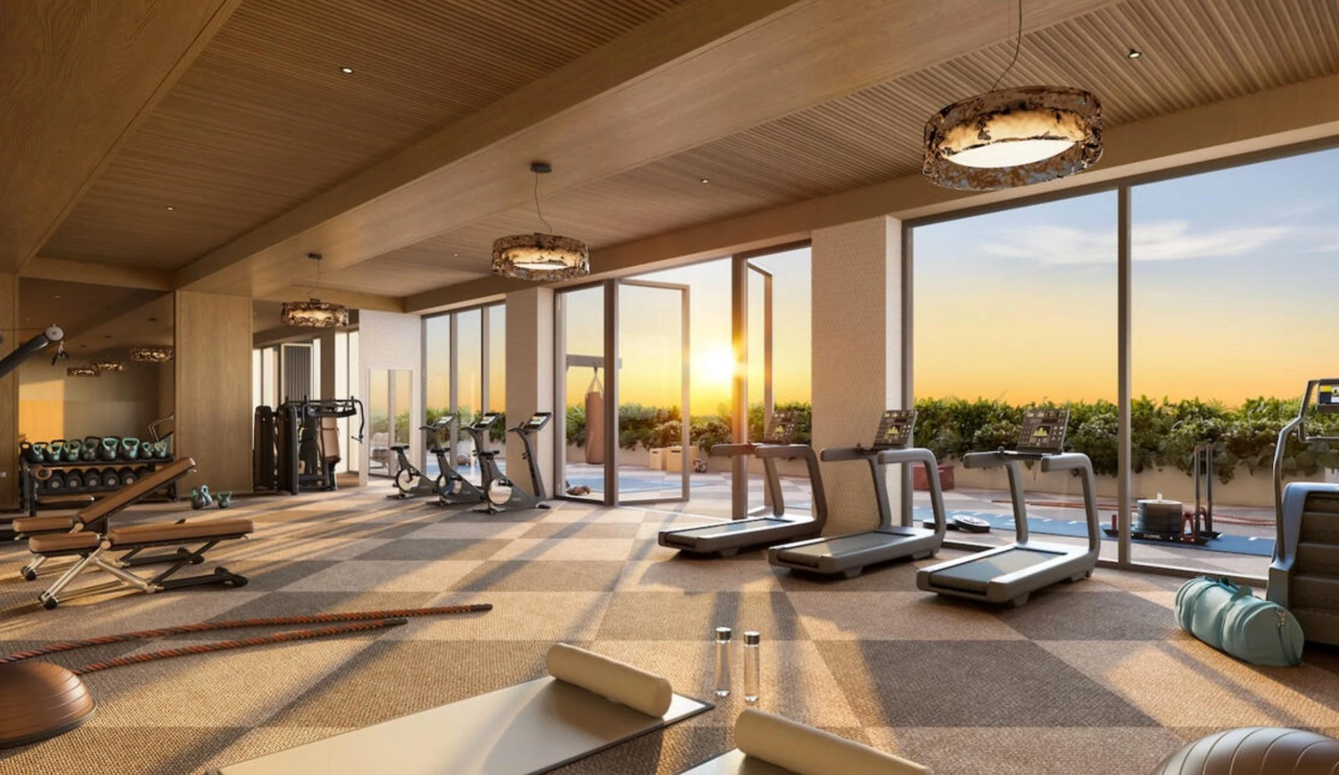 The William — gimnasio con ventanales de piso a techo y vista al atardecer sobre la piscina
