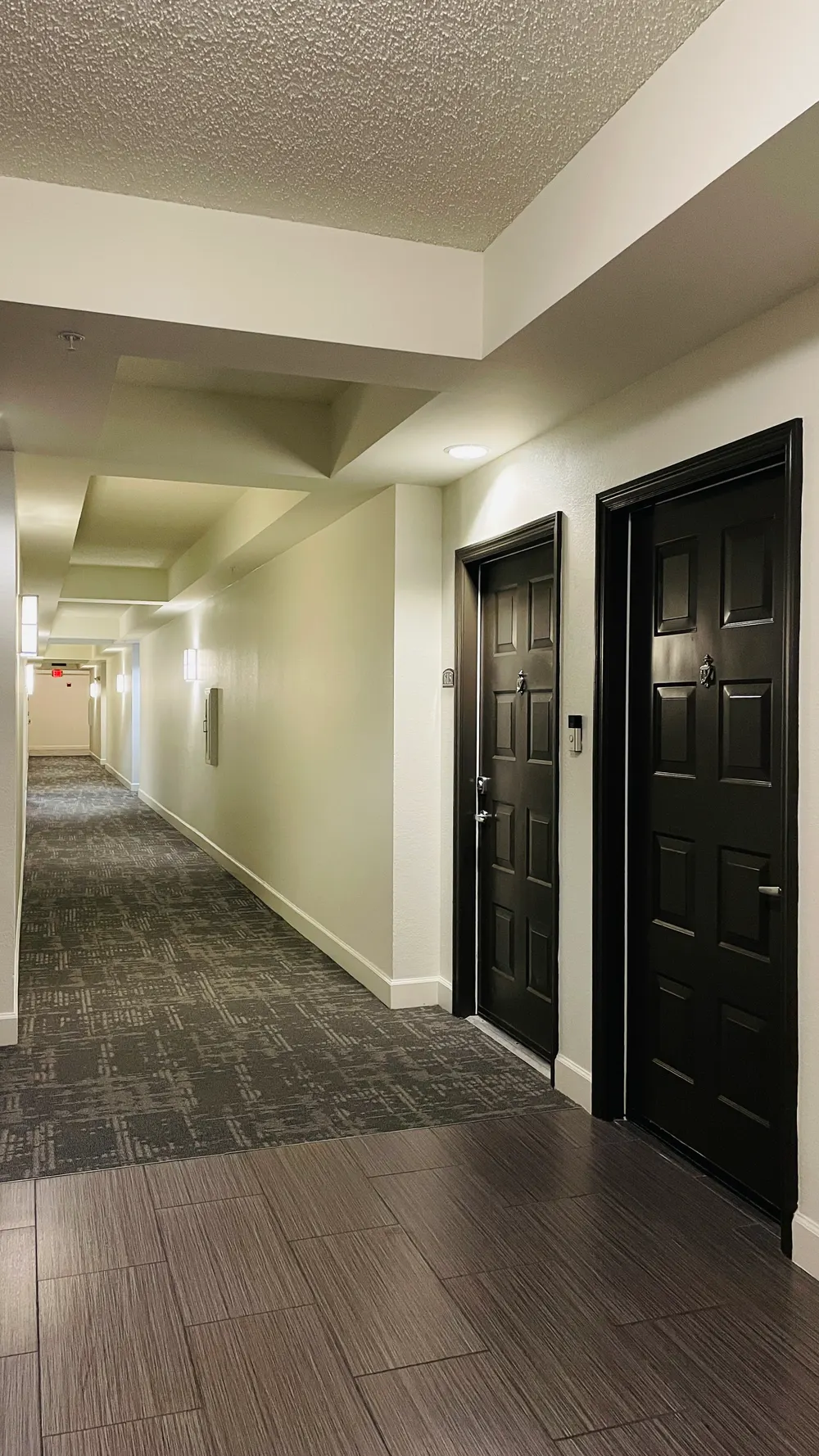 Valencia South Miami — pasillo interior renovado, con puertas oscuras y piso de madera y alfombra