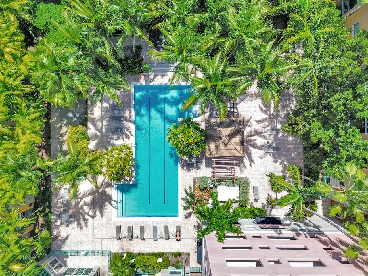 Vista aérea de la piscina y los jardines tropicales de Valencia South Miami, entre los edificios de la comunidad