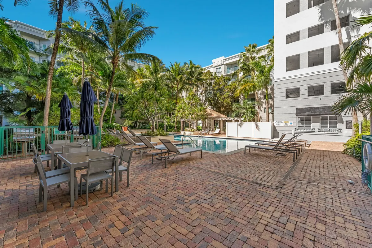 Valencia South Miami — terraza junto a la piscina con mesas, sombrillas y reposeras