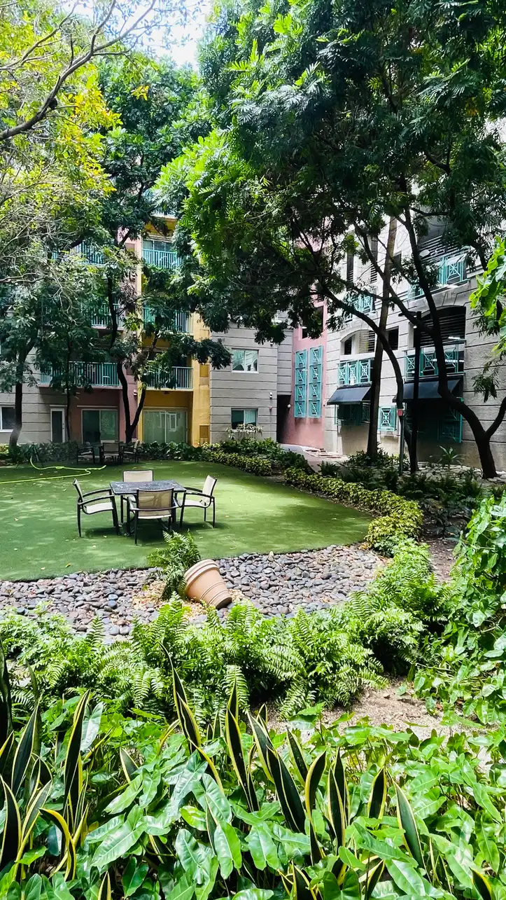 Valencia South Miami — patio y jardín interior con mesa y sillas entre los edificios de la comunidad