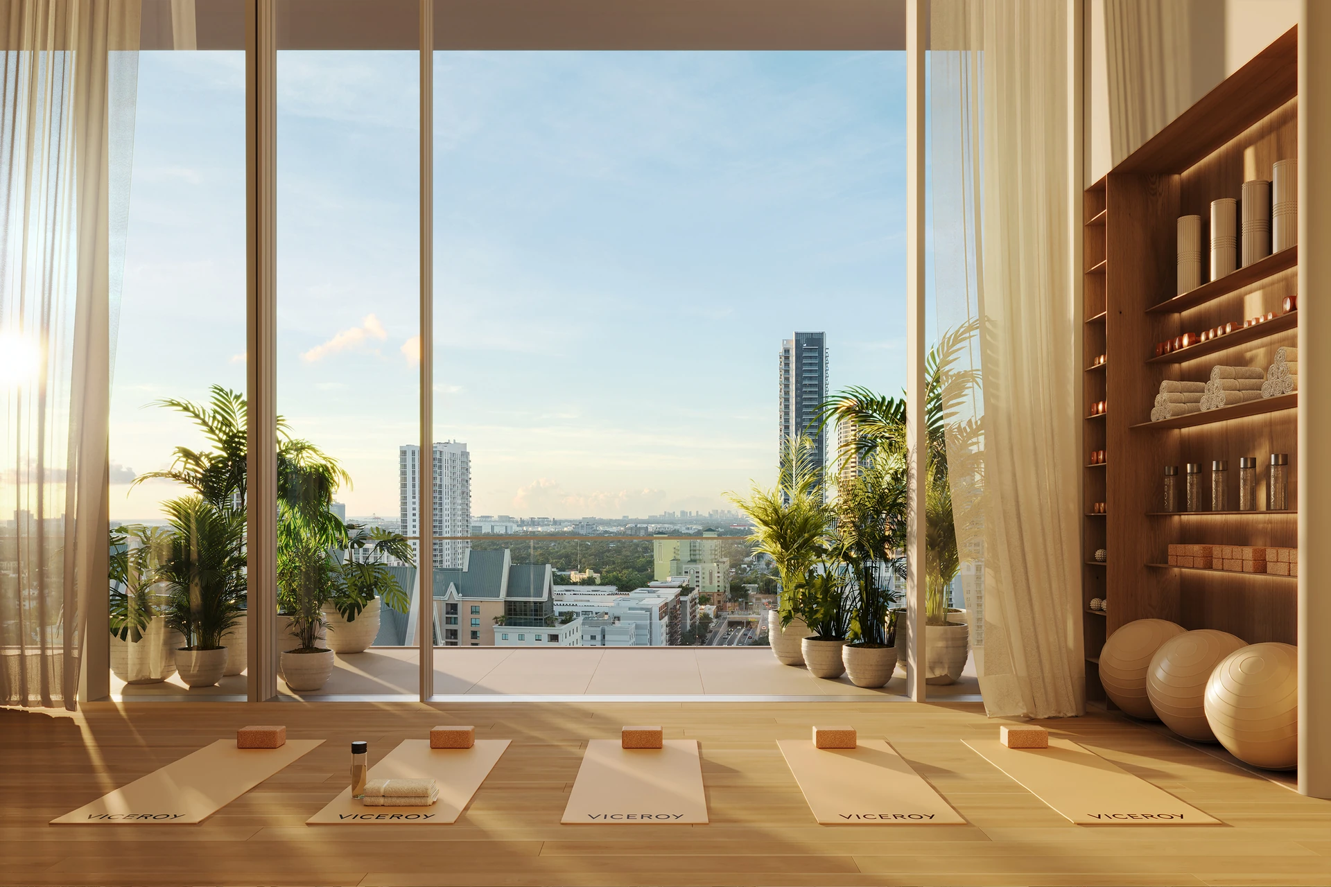 Viceroy Ft. Lauderdale — estudio de yoga con esterillas, plantas y ventanales de piso a techo con vista a la ciudad al amanecer