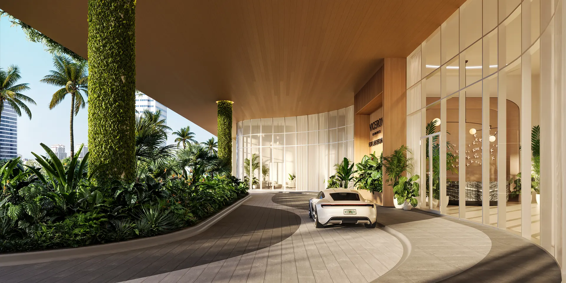 Viceroy Ft. Lauderdale — porte-cochère de llegada, con columna cubierta de vegetación, jardinería tropical y el acceso acristalado al vestíbulo