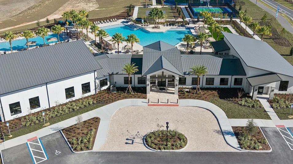 Vista aérea de la casa club de Wellness Ridge, con la piscina y las canchas deportivas de la comunidad
